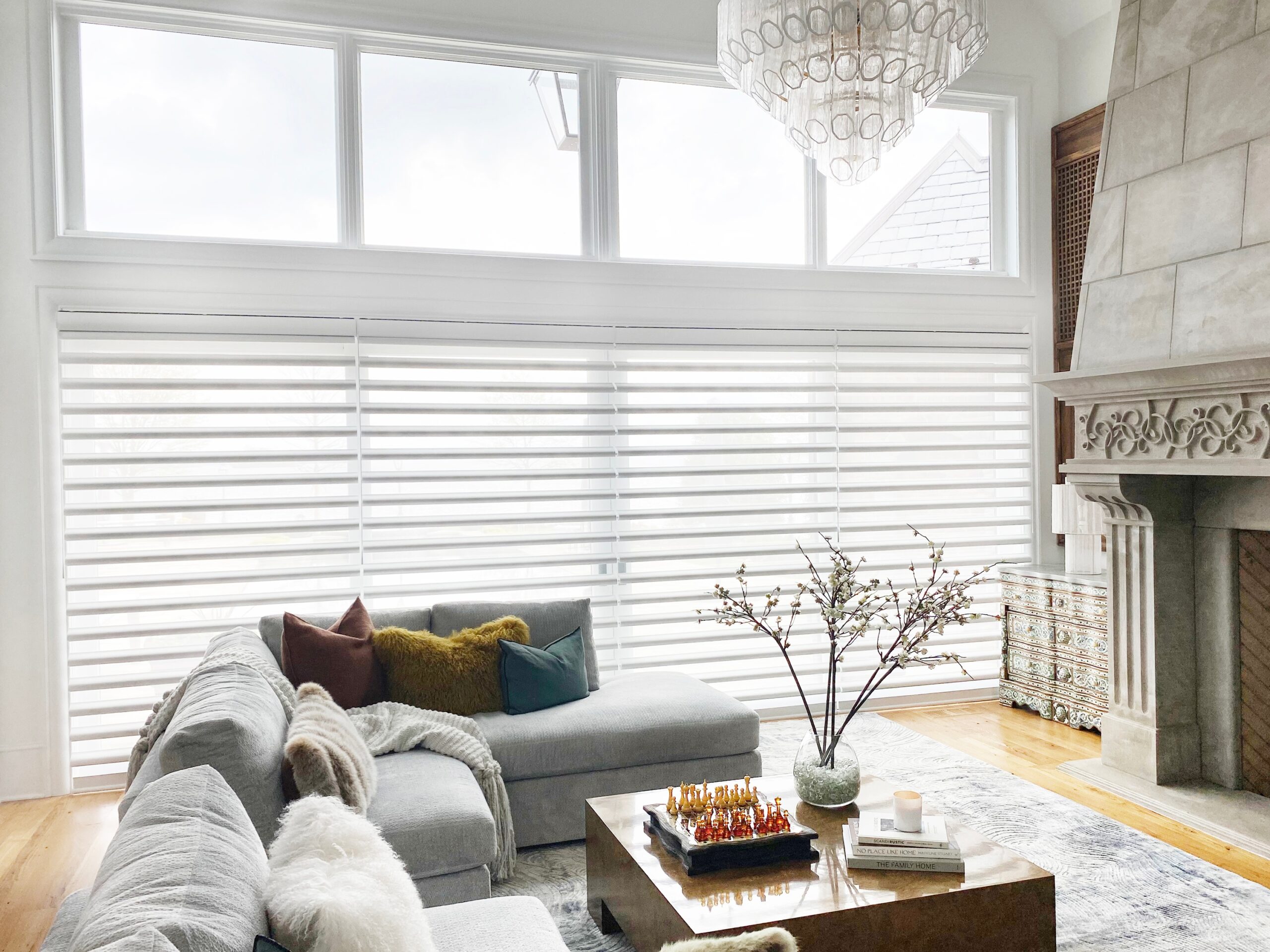 A spacious living area showcasing elegant Pirouette window shades in Shantung Ming Porcelain, complementing the room's serene ambiance.