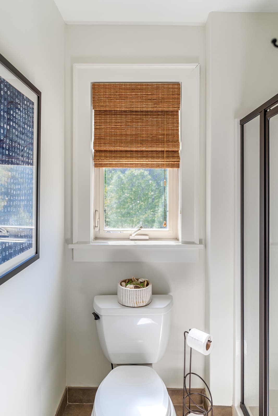 Brown Hunter Douglas Woven Wood in a window over a toilet