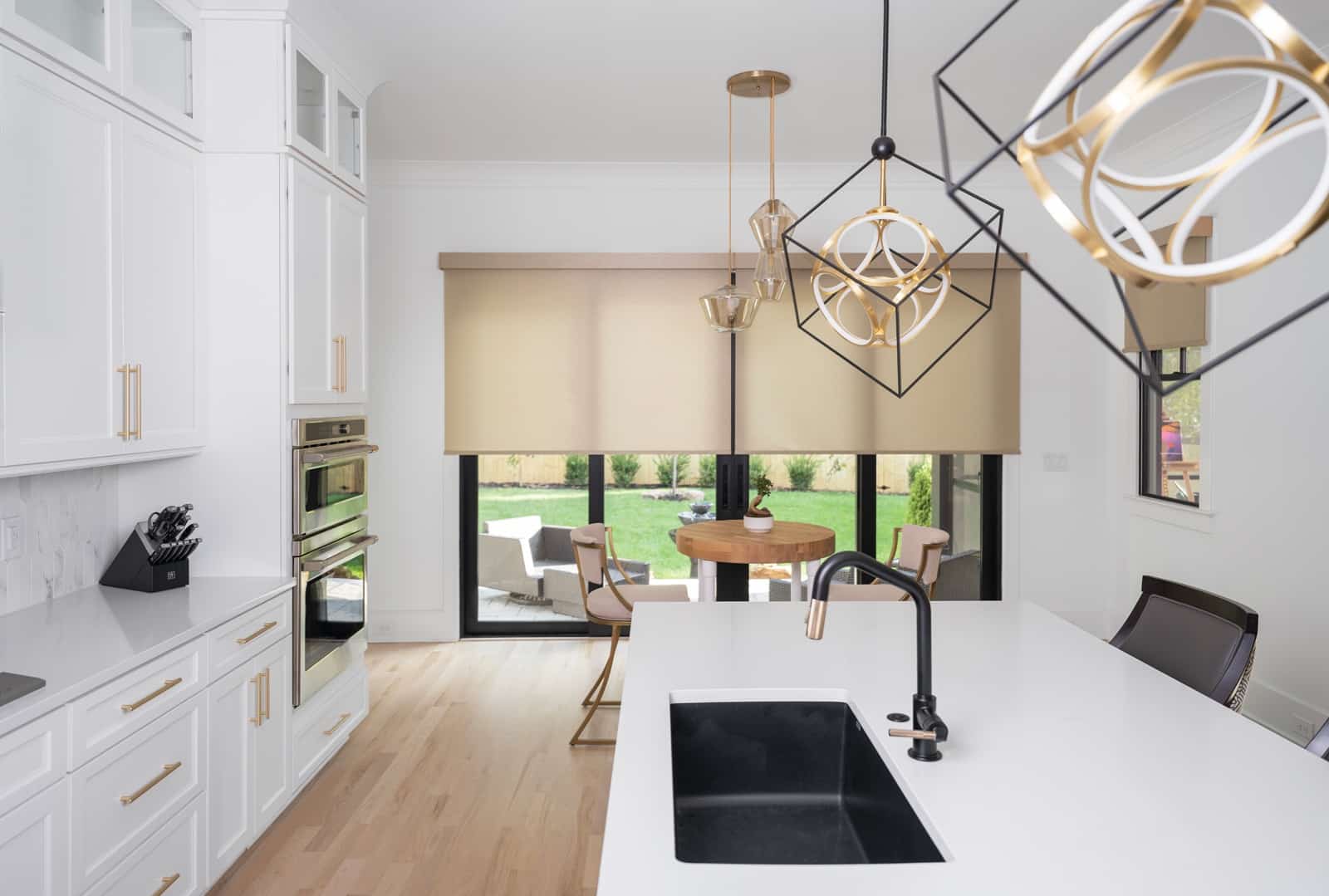 Tan roller shades over a black sliding door in a modern kitchen