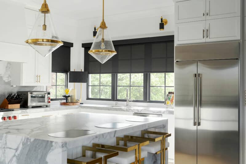 Contemporary kitchen with black roller shades alongside a stainless steel refrigerator in a Davidson, North Carolina home.