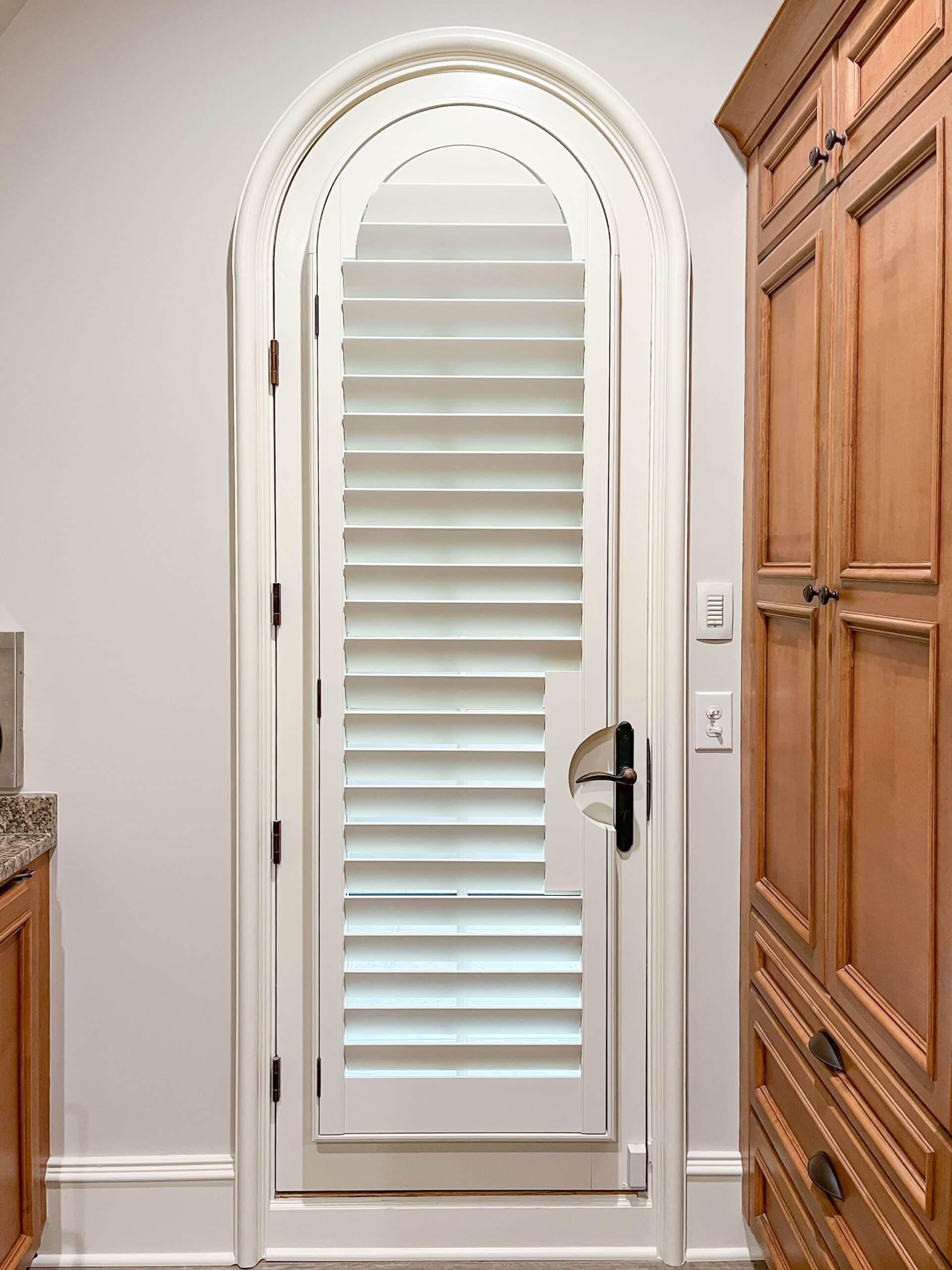 An arch top plantation shutter on an arched door