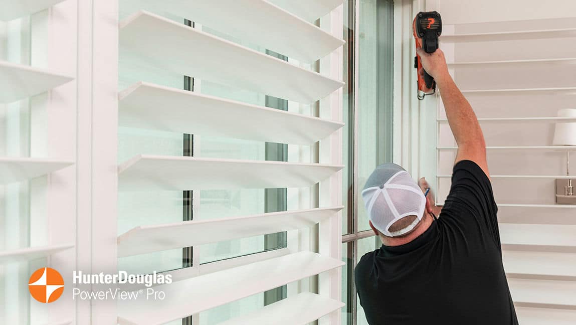 With a keen eye for detail, A Shade Above's technician anchors and adjusts the new window covering