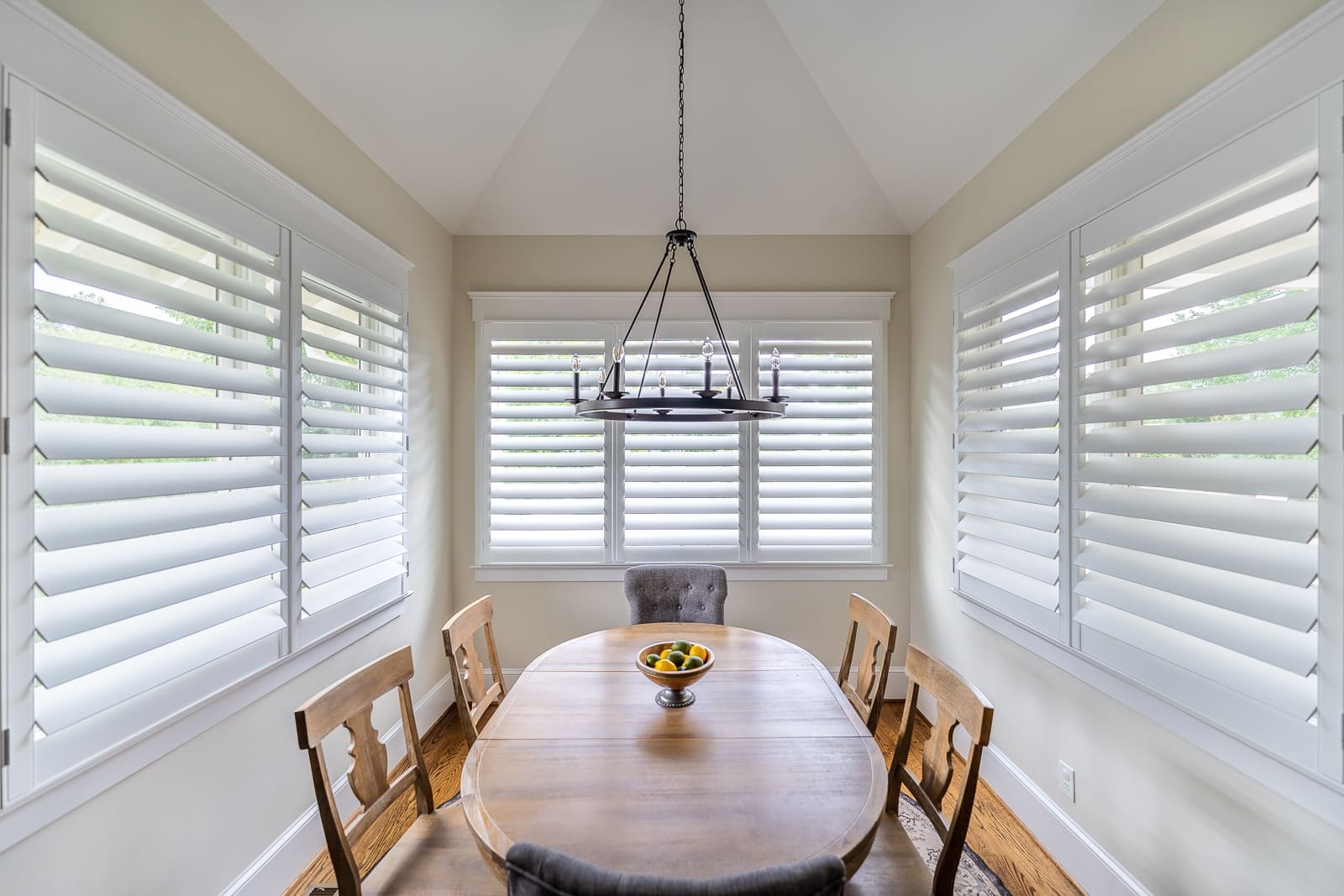 A breakfast nook surrounded by white shutters