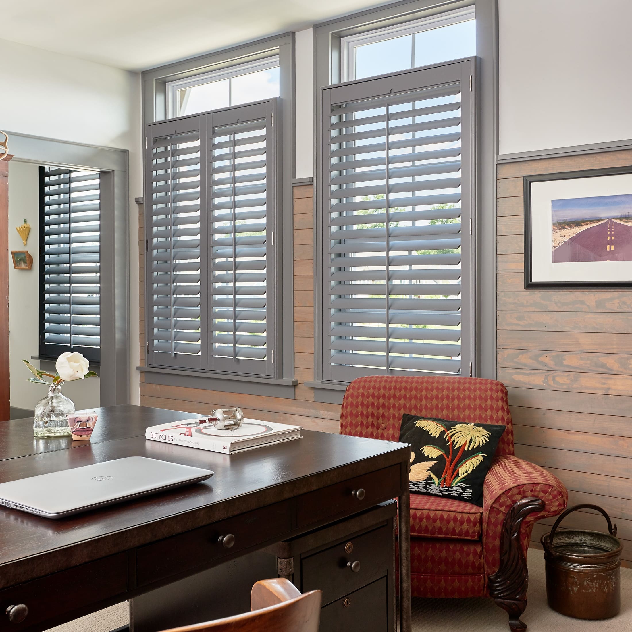 Office space with dark gray plantation shutters and wall-hung bicycles