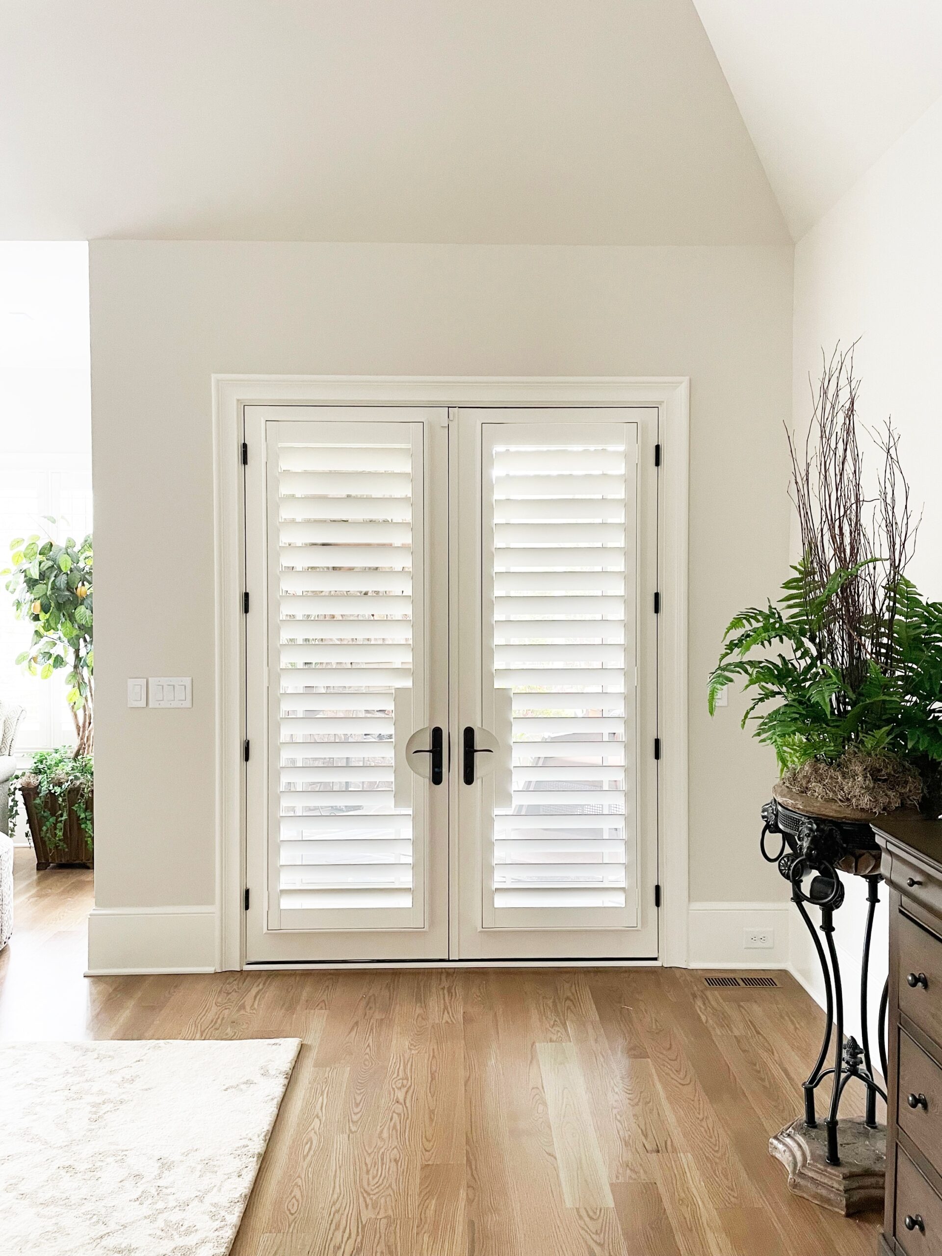 Patio doors with wood shutters mounted with rounded cutouts for door handles