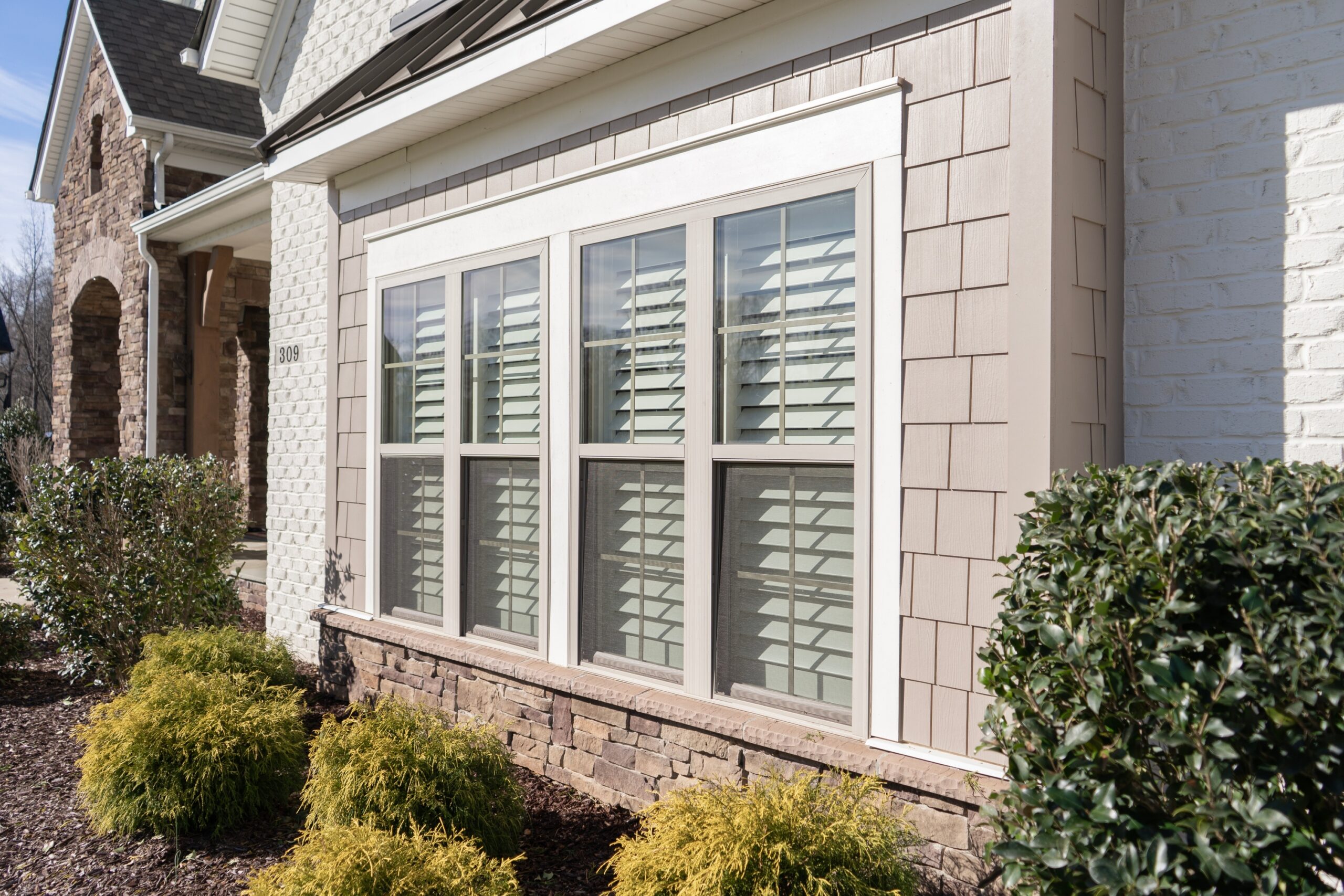 Exterior view of a garage window with interior wood shutters