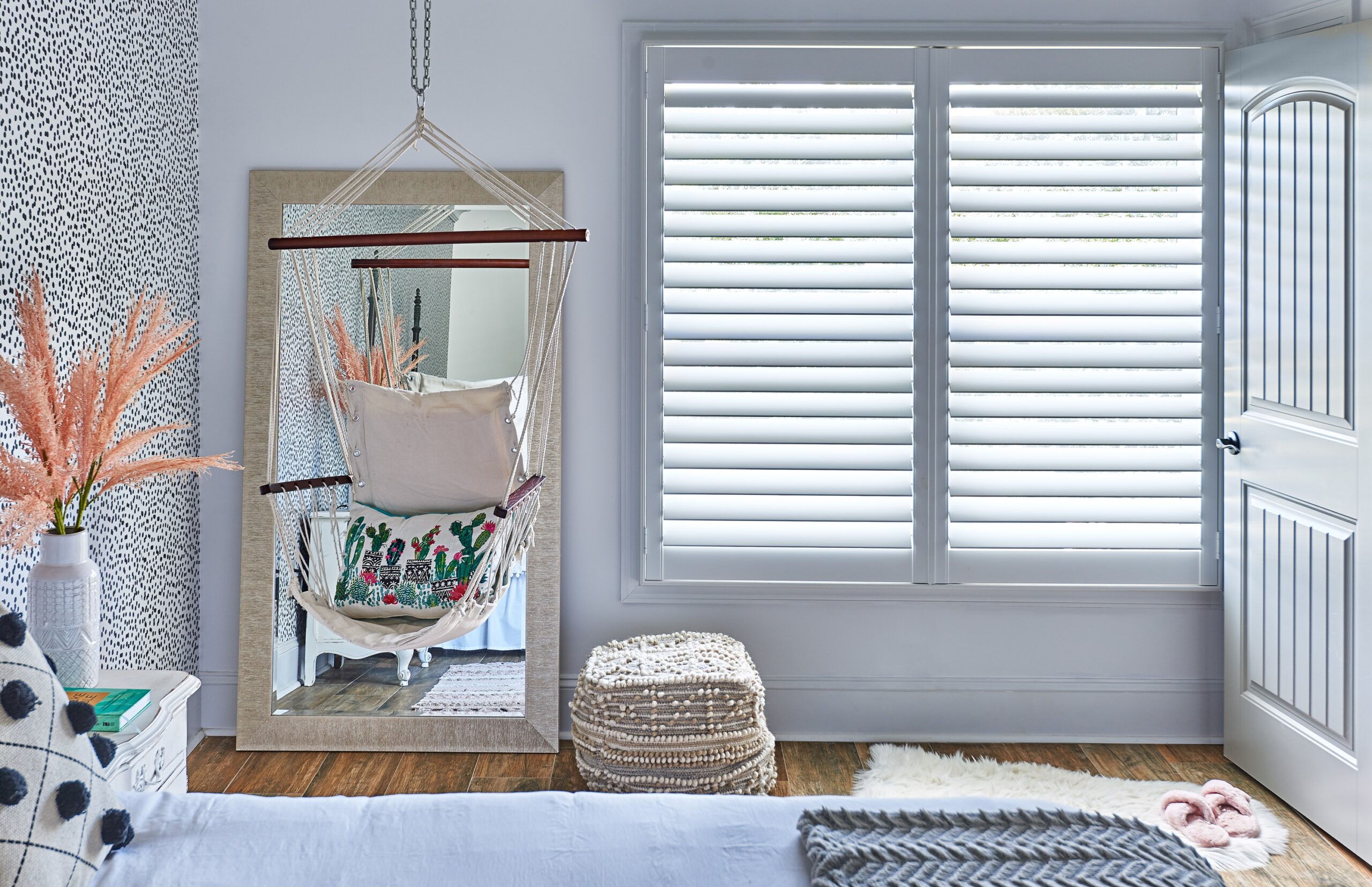 Swinging chair in a teen's bedroom next to white hidden tilt shutters