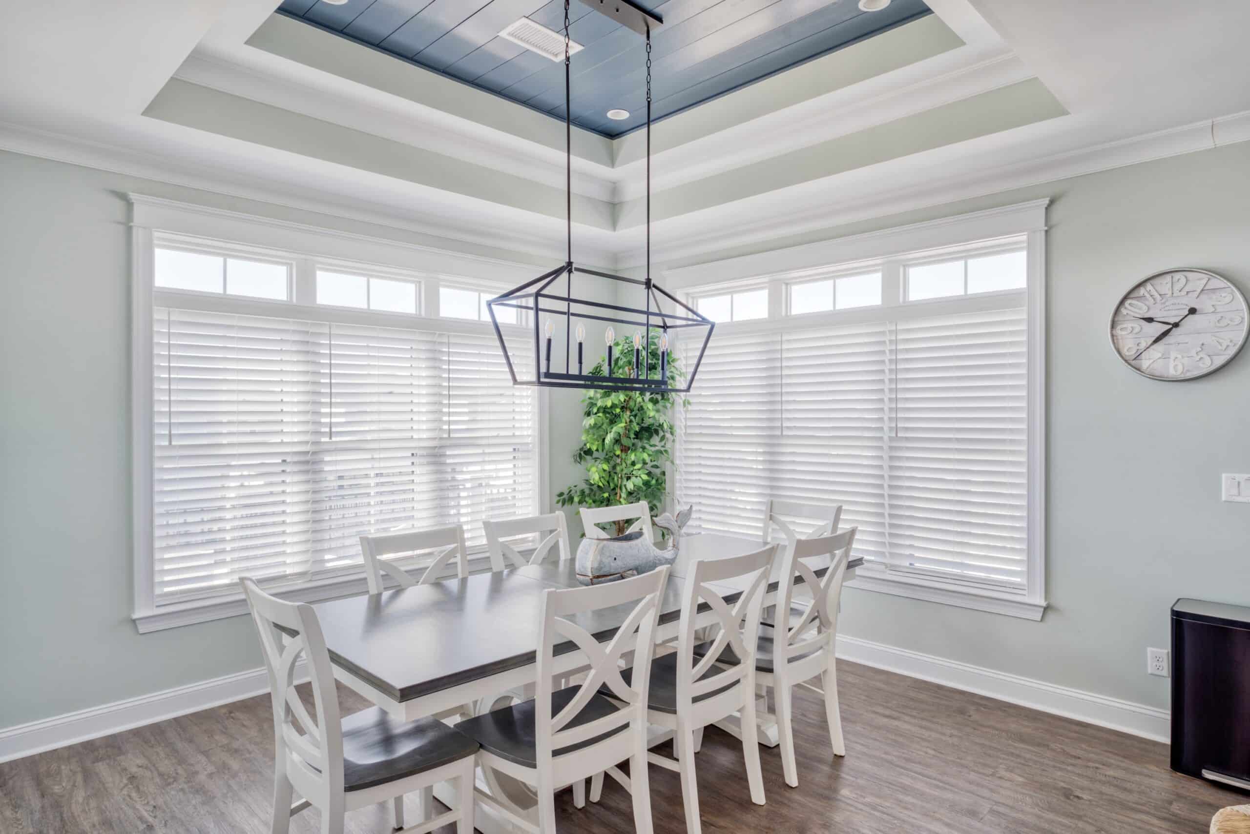 Light, airy kitchen with large dining table and white faux wood blinds