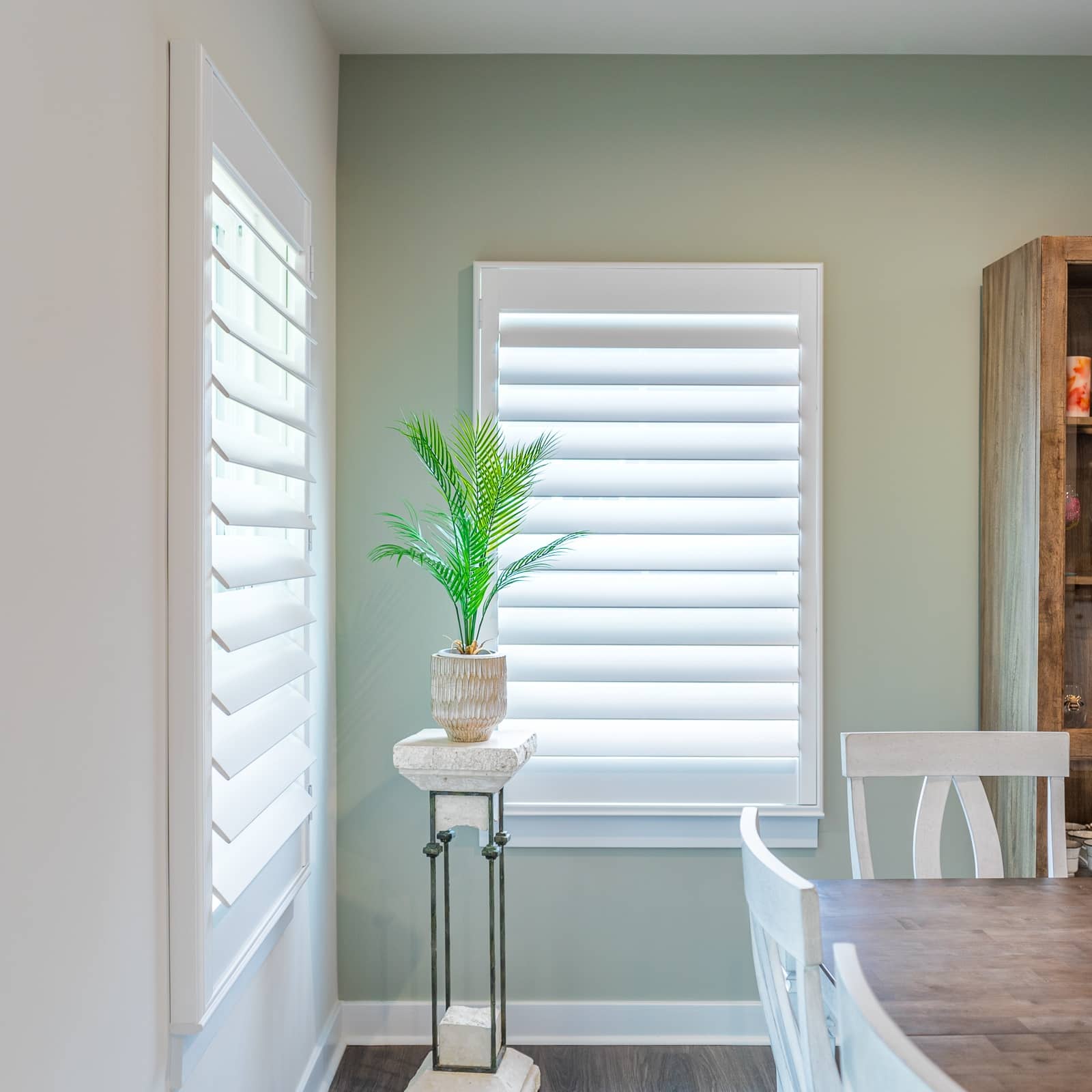 White wood shutters beside a green house plant