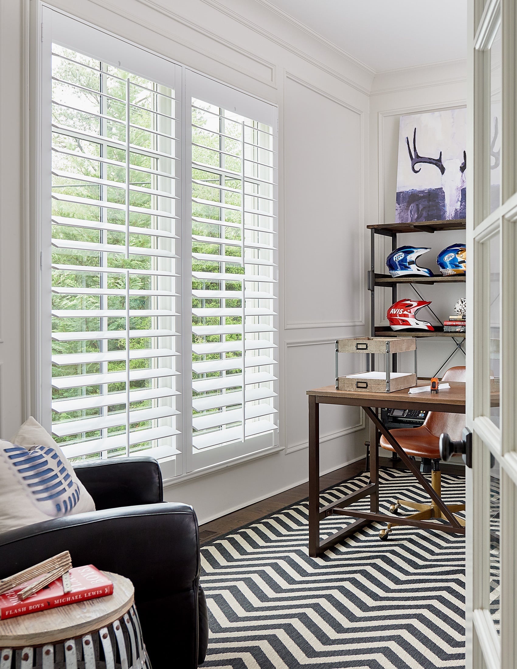 A chic transitional office with a racing theme featuring large plantation shutters