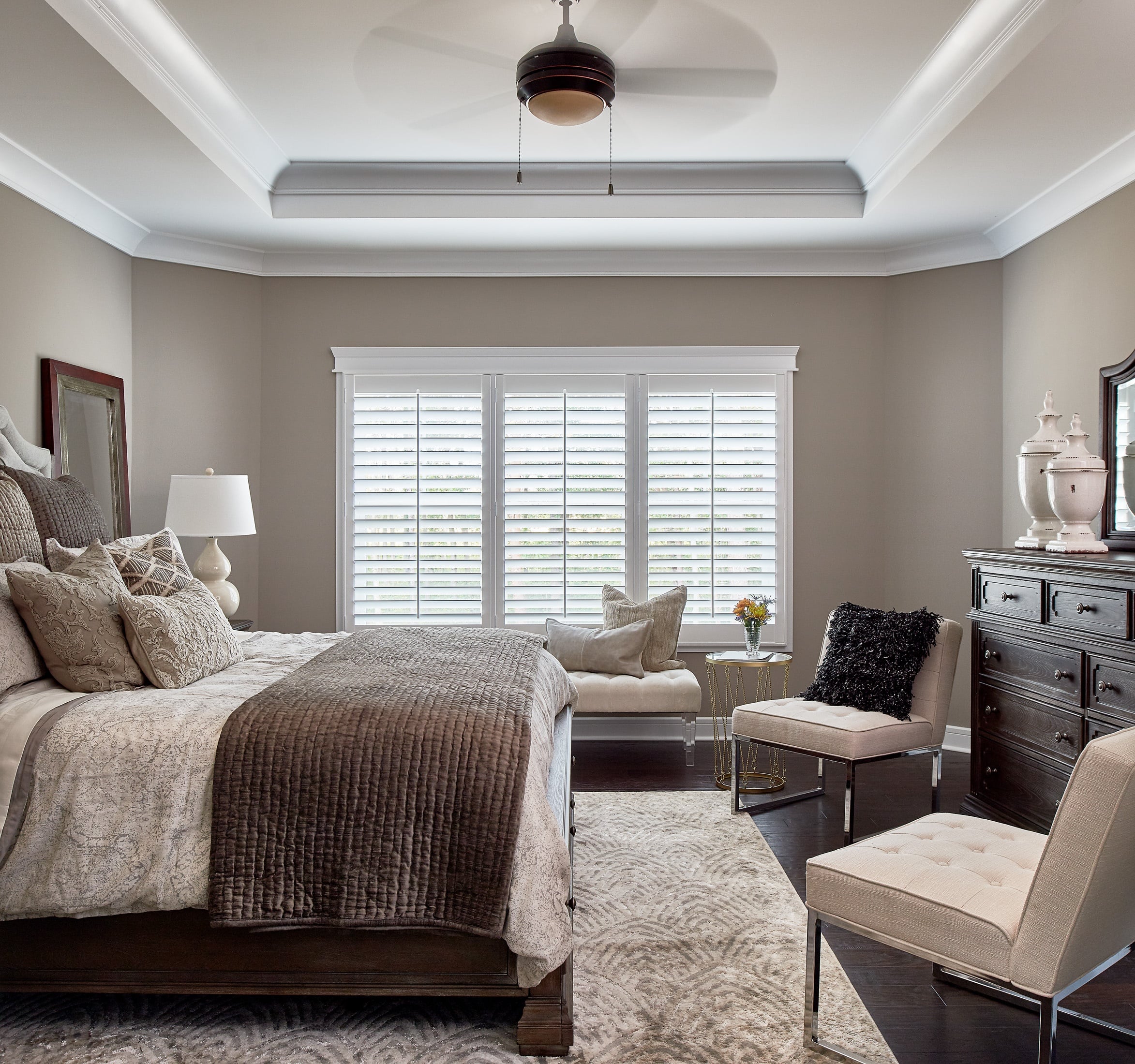 Primary bedroom of a home featuring a large triple set of shutters