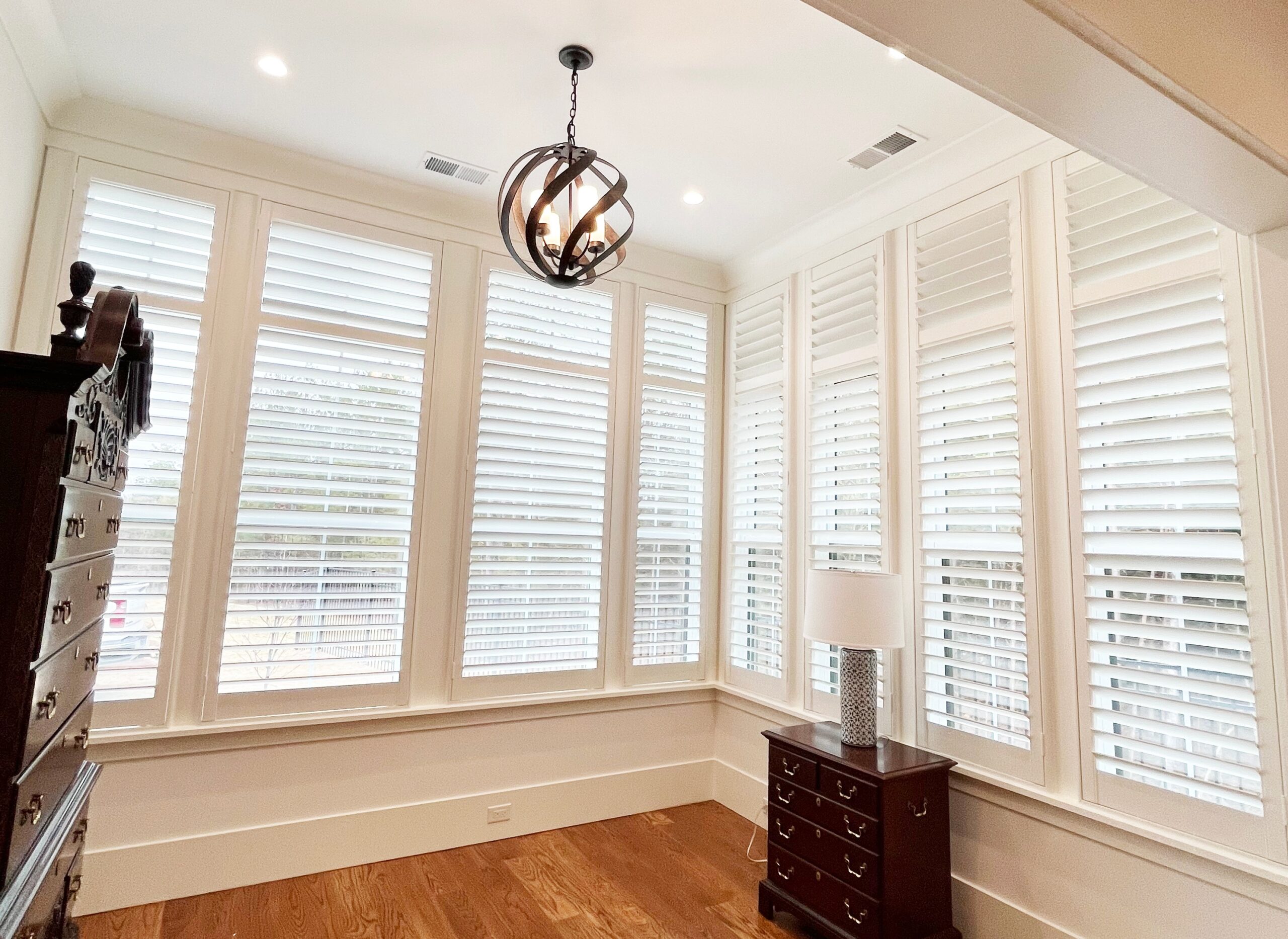 Tall window shutters in an empty office with hardwood floors