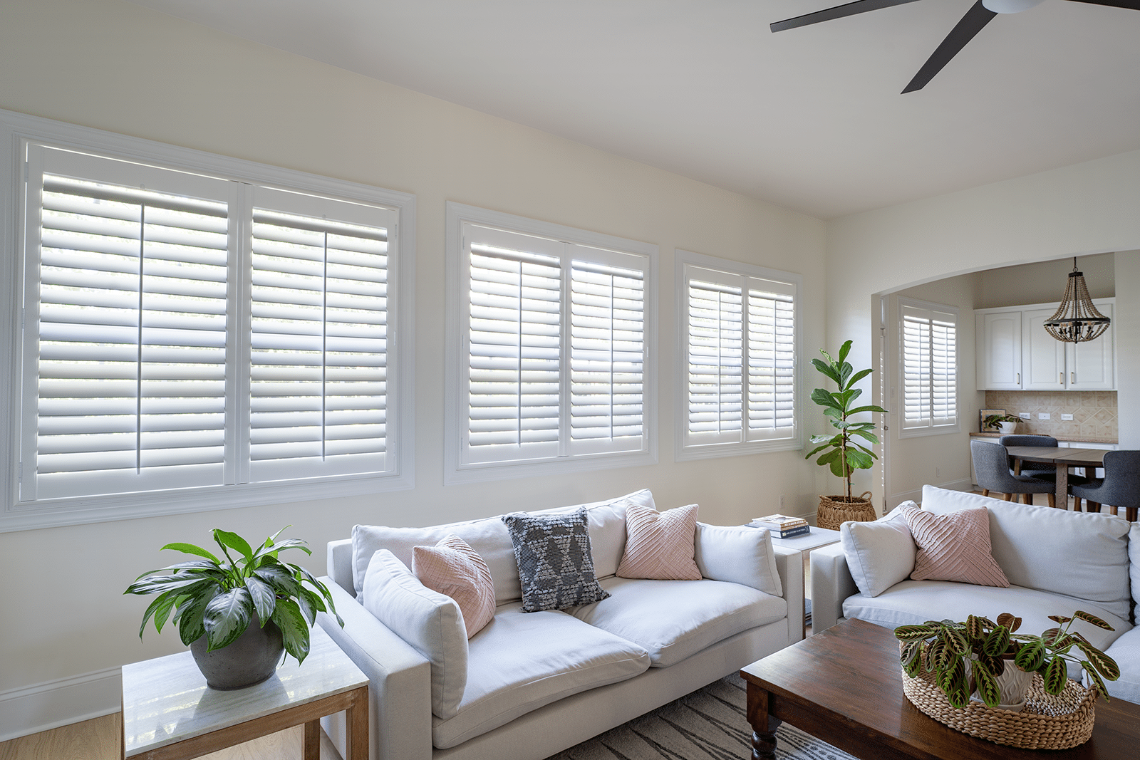 A large span of windows covered by plantation shutters in a living room