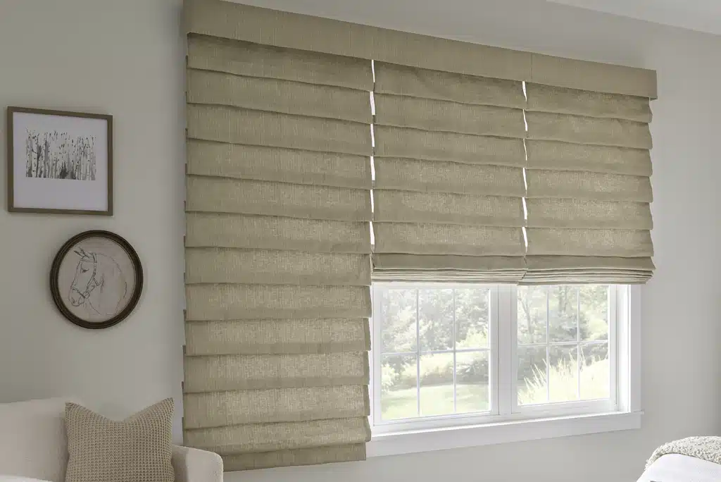 Three linen roman shades hang over a bedroom window