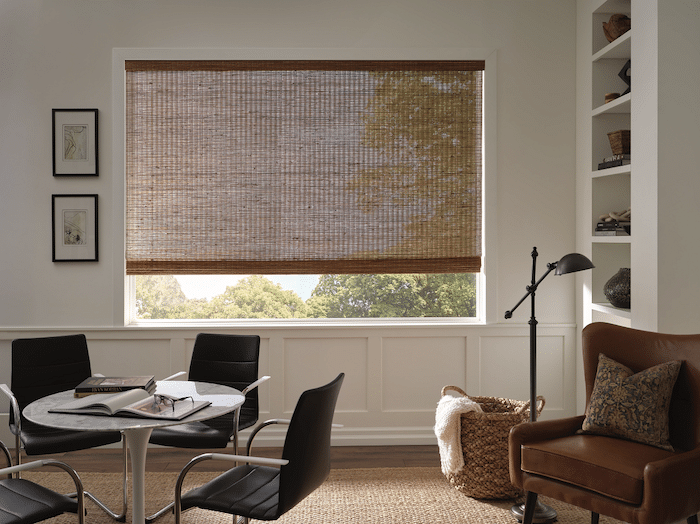 A semi-sheer woven wood shade hanging in a farmhouse modern office