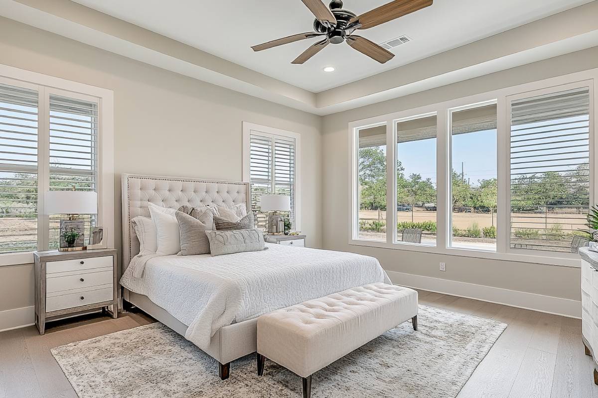 A modern bedroom with interior plantation shutters in white and neutral colors at A Shade Above Window Fashions near Charlotte and Cornelius, NC & North Myrtle Beach, SC