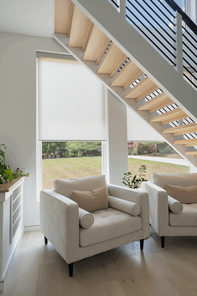 Motorized roller shades covering tall windows in a modern North Carolina home with clean lines