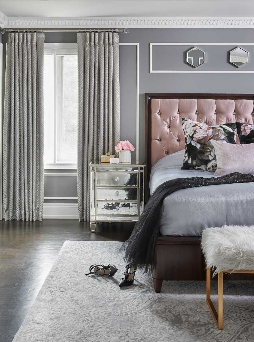 gray bedroom with pink upholstered headboard and pinch pleat draperies