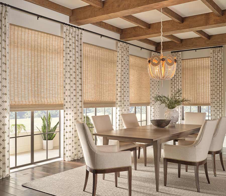 dining room with woven wood shades and layered draperies