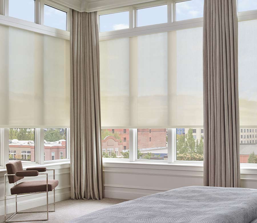 Floor-to-ceiling windows with Designer Roller Shades with PowerView® Automation, Layered with Custom Side Drapery Panels in bedroom overlooking downtown cityscape