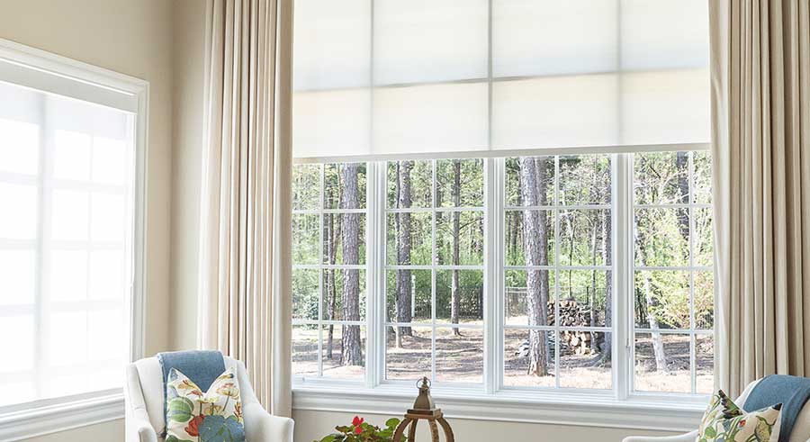 White roller shade covering a large window in a sitting room within a Mint Hill, NC home