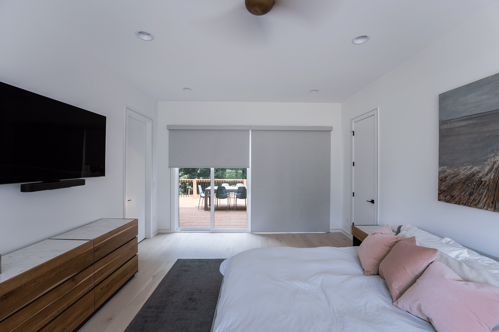 Designer roller shades on Charlotte NC bedroom sliding glass doors providing room-darkening light control at sunrise